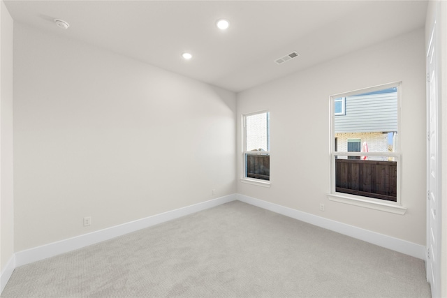 unfurnished room with baseboards, recessed lighting, visible vents, and light colored carpet