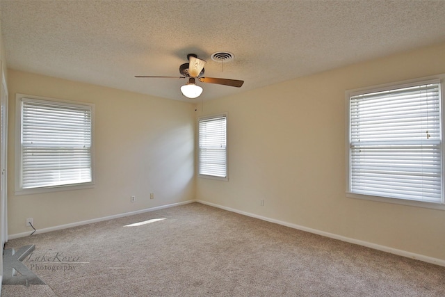 unfurnished room with ceiling fan, light colored carpet, and a textured ceiling