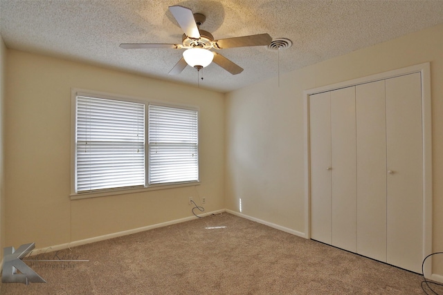 unfurnished bedroom with ceiling fan, light carpet, a closet, and a textured ceiling