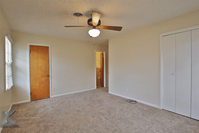 unfurnished bedroom with ceiling fan, a closet, carpet floors, and a textured ceiling