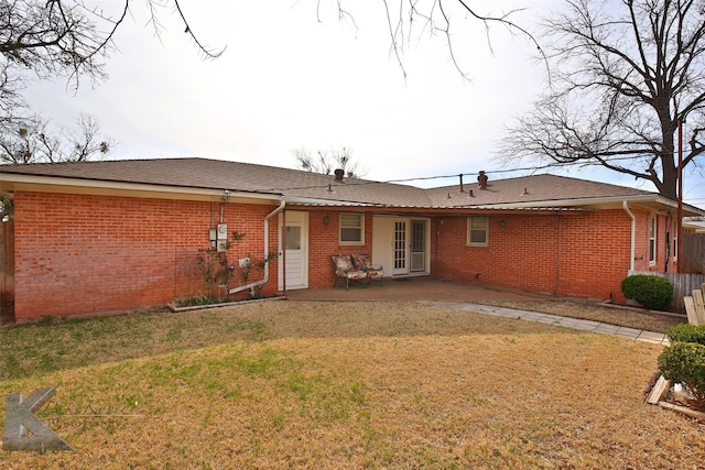 rear view of property with a lawn and a patio