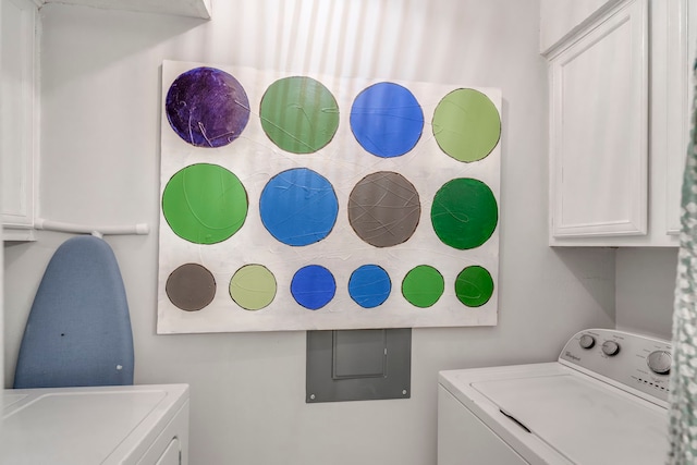 laundry room featuring washer and clothes dryer and cabinets