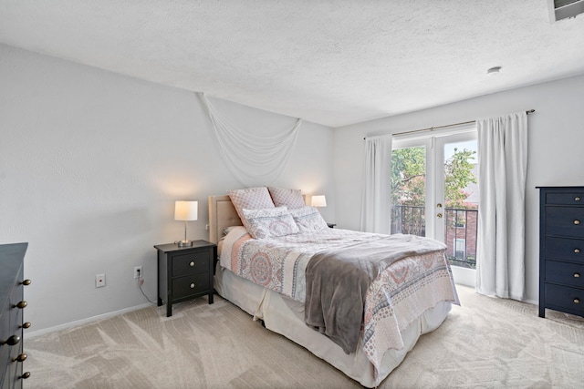 carpeted bedroom with access to outside and a textured ceiling