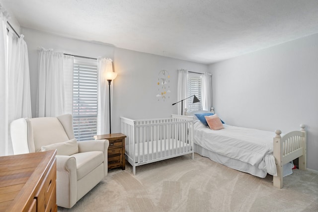 bedroom featuring light colored carpet and a textured ceiling