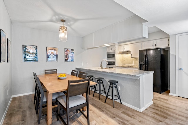 dining area with light hardwood / wood-style floors and sink