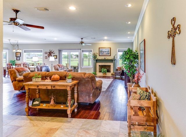 living room featuring ornamental molding, ceiling fan with notable chandelier, and hardwood / wood-style flooring