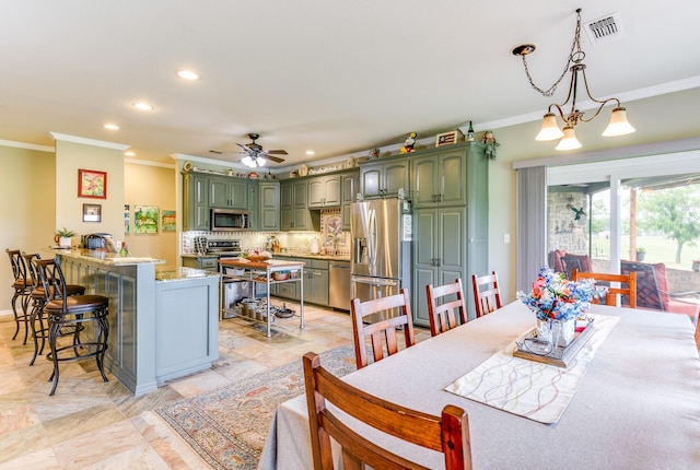 dining area with ceiling fan with notable chandelier and ornamental molding