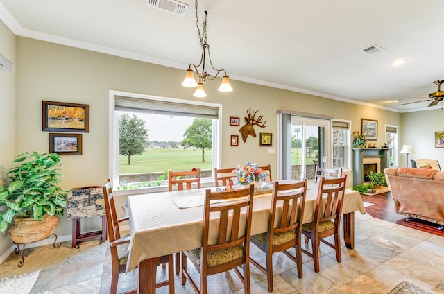 dining area featuring ceiling fan with notable chandelier and crown molding