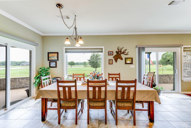 dining room featuring crown molding, light tile patterned floors, and an inviting chandelier