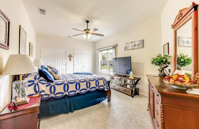 bedroom featuring ceiling fan and two closets