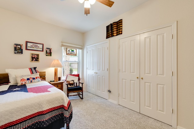 carpeted bedroom with multiple closets and ceiling fan