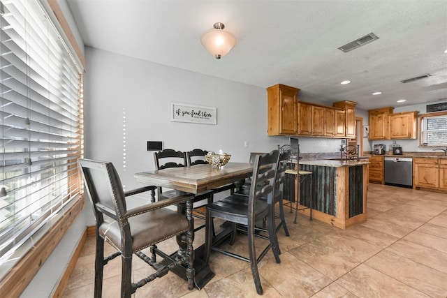 dining area featuring a textured ceiling and light tile patterned floors