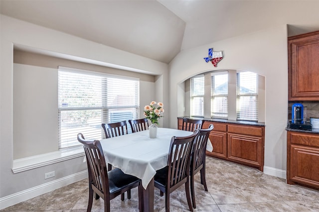 dining area featuring a healthy amount of sunlight and vaulted ceiling