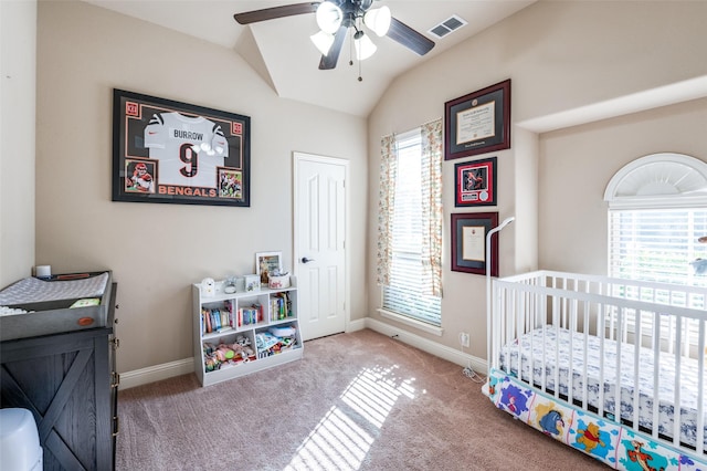 carpeted bedroom featuring ceiling fan, lofted ceiling, and a crib