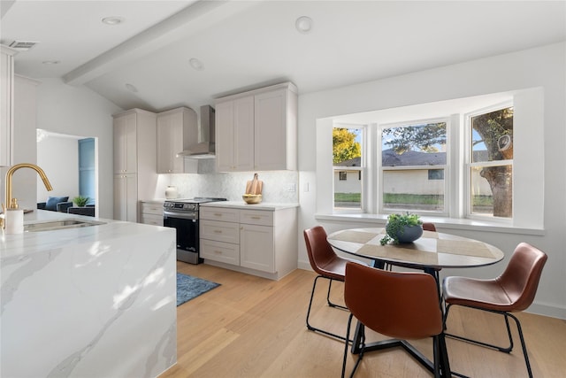 kitchen with white cabinets, sink, wall chimney exhaust hood, and stainless steel range with electric cooktop