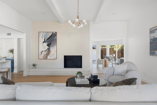 living room featuring light hardwood / wood-style floors, a notable chandelier, and beamed ceiling