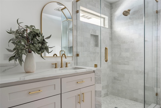 bathroom featuring vanity and a shower with door