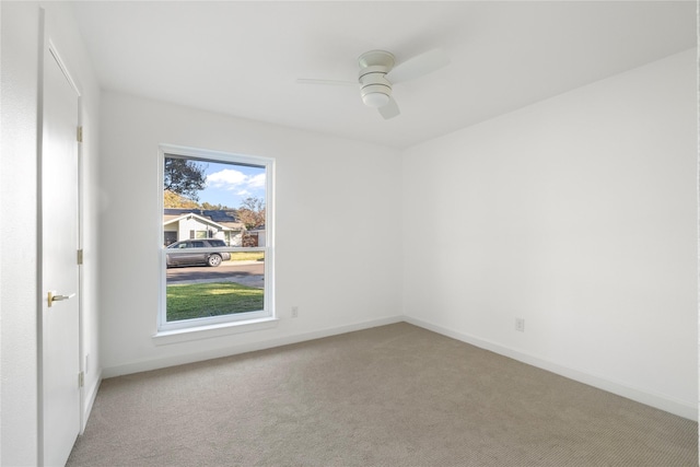 carpeted spare room featuring ceiling fan