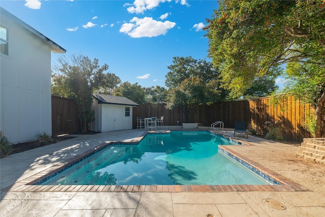 view of swimming pool featuring a patio and a shed