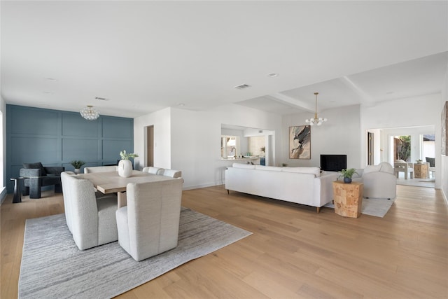 living room featuring light hardwood / wood-style flooring and a notable chandelier