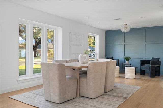 dining room with plenty of natural light, an inviting chandelier, and light hardwood / wood-style floors