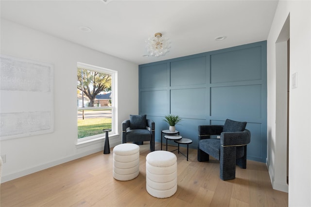 living area featuring an inviting chandelier and light hardwood / wood-style floors