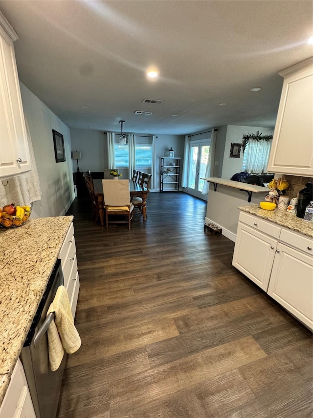 kitchen with light stone countertops, white cabinetry, and dishwasher