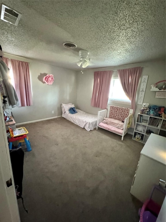 carpeted bedroom with a textured ceiling and ceiling fan