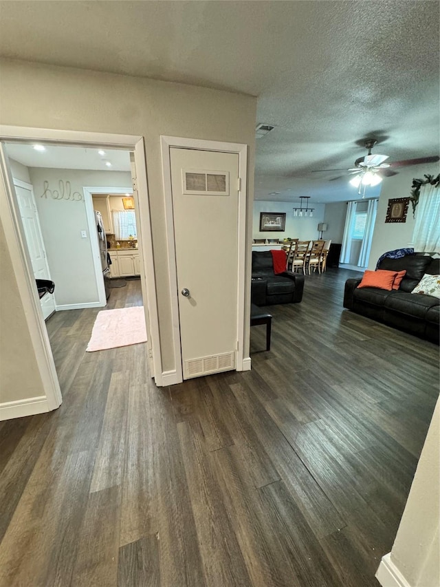 hall featuring dark wood-type flooring and a textured ceiling