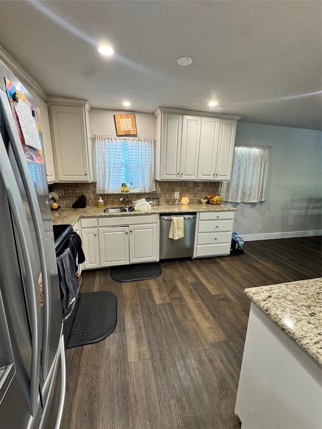 kitchen with white cabinetry, dark hardwood / wood-style flooring, stainless steel appliances, sink, and light stone counters