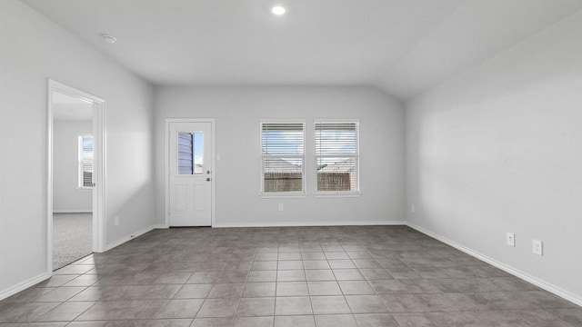 foyer entrance featuring vaulted ceiling, tile patterned floors, and plenty of natural light