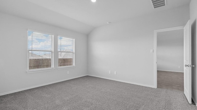 empty room with carpet and vaulted ceiling