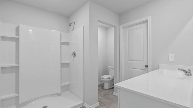 bathroom with toilet, walk in shower, and vanity