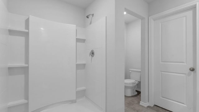 bathroom featuring toilet and walk in shower