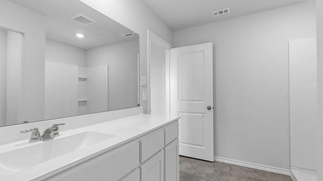 bathroom featuring a shower and vanity