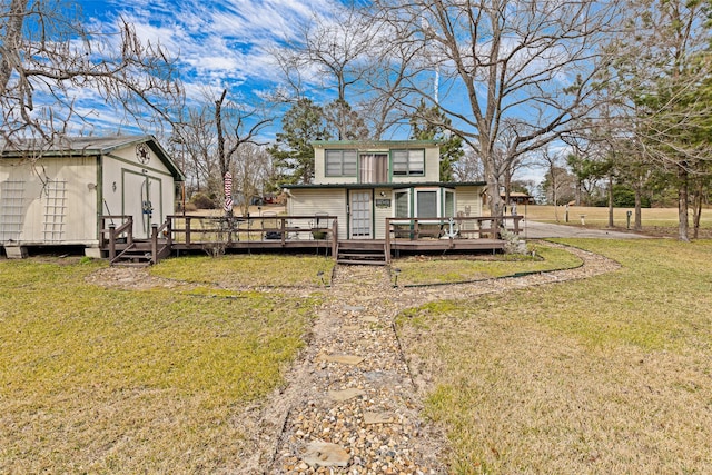 rear view of house with a storage shed, a deck, and a lawn