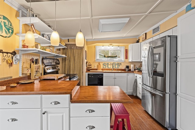 kitchen featuring stainless steel appliances, sink, pendant lighting, and butcher block countertops