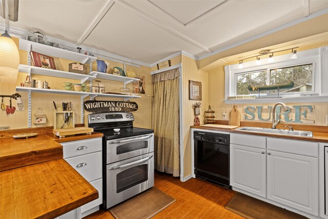 kitchen with pendant lighting, butcher block countertops, sink, white cabinetry, and appliances with stainless steel finishes