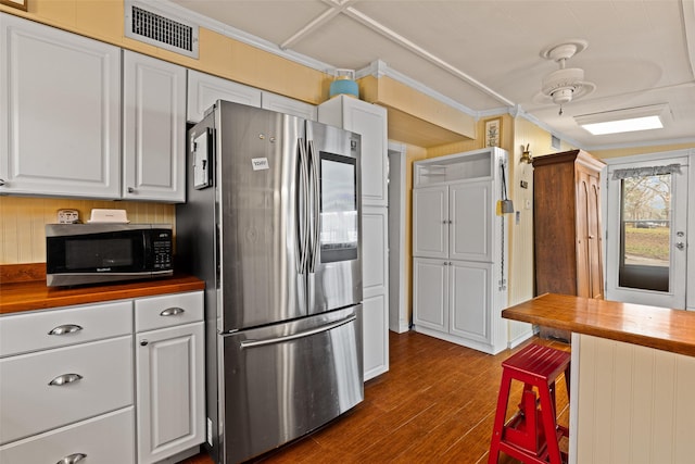 kitchen with wood counters, dark hardwood / wood-style flooring, stainless steel refrigerator, and white cabinets