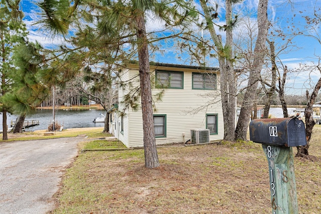 view of front of property with a water view and central AC