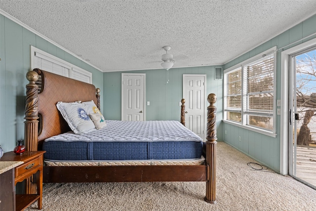 bedroom featuring ceiling fan, access to exterior, carpet, and wood walls