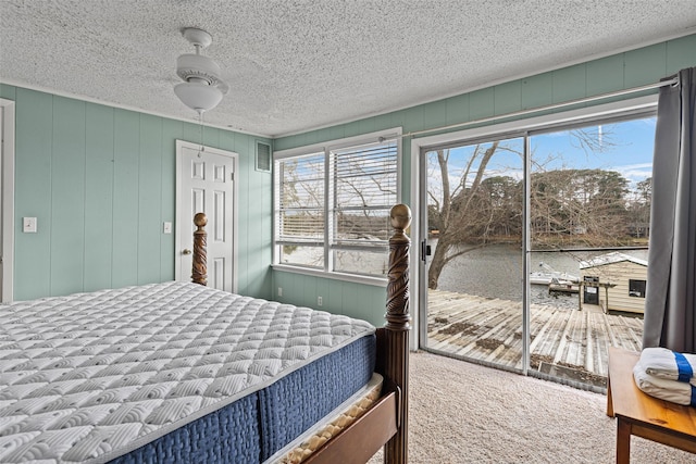 bedroom featuring multiple windows, a textured ceiling, and carpet