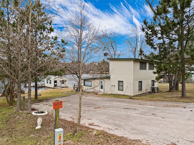 exterior space with central AC unit and a front lawn