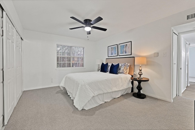 carpeted bedroom featuring ceiling fan and a closet