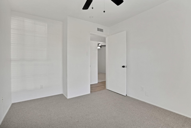 carpeted spare room with ceiling fan