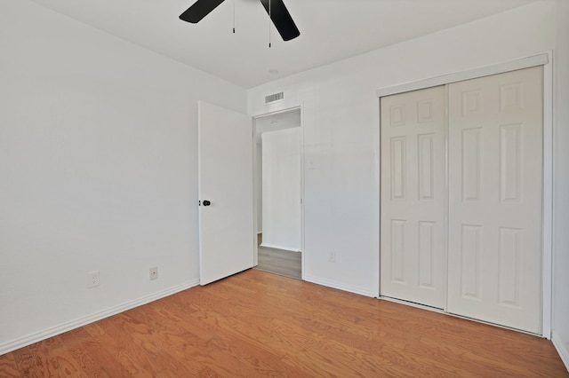 unfurnished bedroom with ceiling fan, light hardwood / wood-style flooring, and a closet