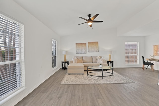 living room with ceiling fan, plenty of natural light, lofted ceiling, and hardwood / wood-style floors