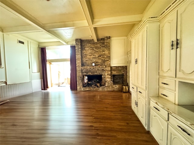 unfurnished living room with dark hardwood / wood-style flooring, beam ceiling, a fireplace, and coffered ceiling