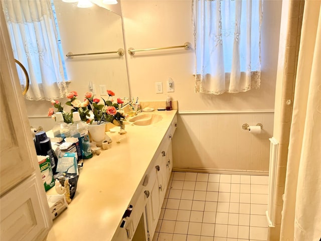 bathroom featuring tile patterned floors, vanity, and wooden walls