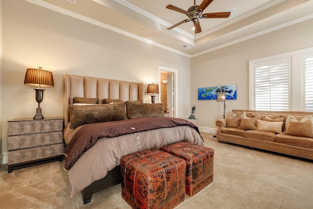 bedroom featuring light colored carpet, a tray ceiling, ceiling fan, and ornamental molding